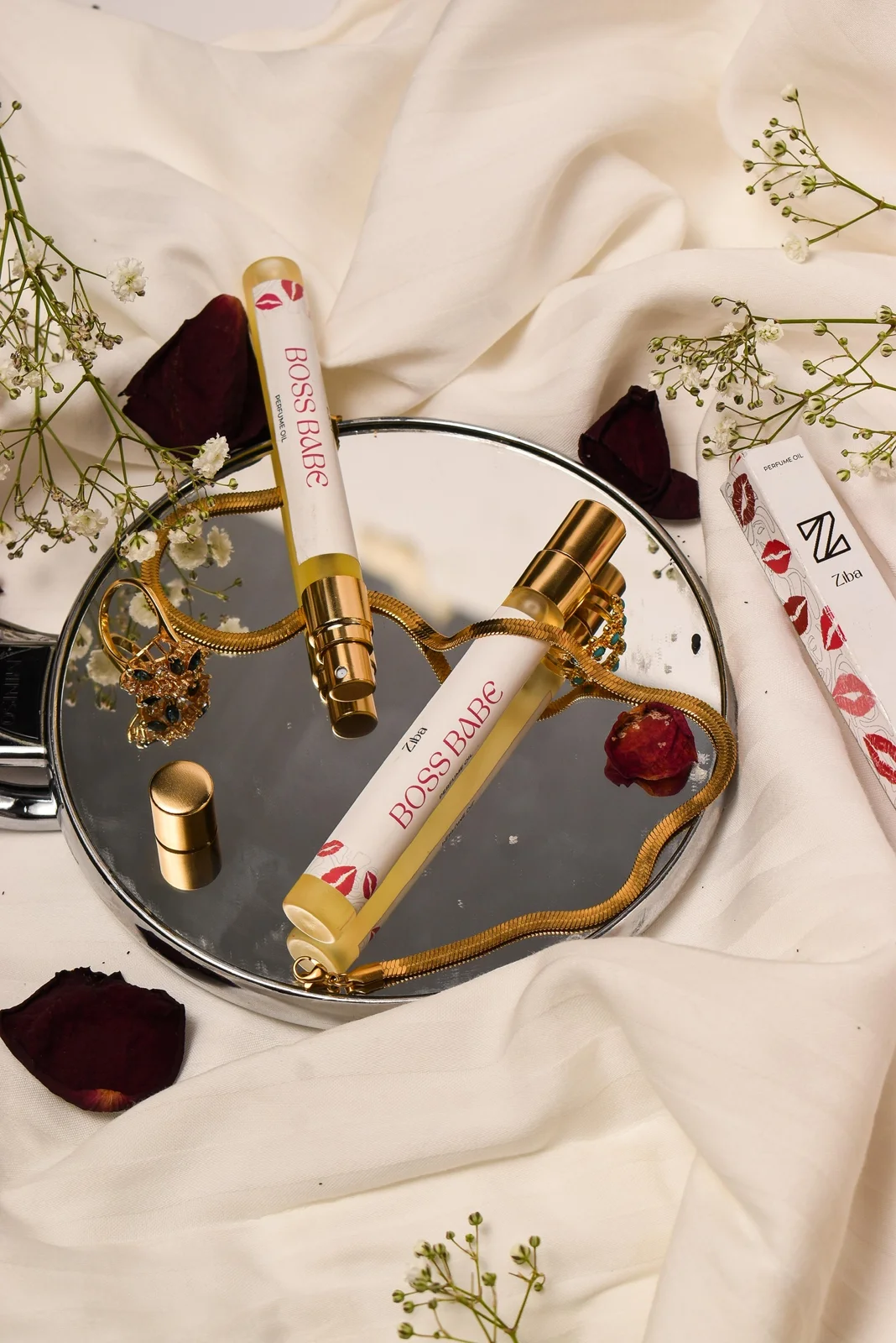 Boss Babe perfume styled with flowers, satin and gold accessories